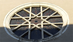 TOUL SYNAGOGUE, BUILT: 19TH CENTURY. THIS IS THE ROSE WINDOW ABOVE THE TORAH ARK. ABOUT THE SYNAGOGUE: The Synagogue of Toul is situated 15, Rue de la Halle (wheat) at Toul in Meurthe-et-Moselle (54). Built on the ruins of the church of St. Amand's Catholic Cemetery (old parish of St. Amand). Between 1790 and 1840 the Jewish population had 500 members over 7500 people that included the city of Toul. This synagogue was built in 1812, redeveloped under the Second Empire by the architect in the Moorish style Fisson (inaugurated on 18/10/1862). Ancient Hebrew school built in 1869. It is owned by a religious association and is no longer used today, the Jewish community of Toul is extremely reduced. Rabbi's house that was sold is contiguous. The gate leading to the synagogue is fenced and locked. The building itself is abandoned and is slowly falling into disrepair.